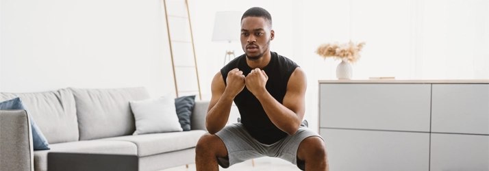 A person squatting in their living room.