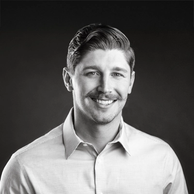 Chiropractor Brennan Martin smiling. The photo is black and white.